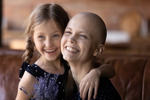 Fotografía en la que una mujer con cáncer abraza a su hija.