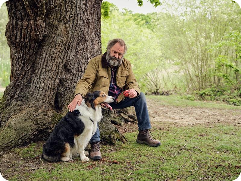 Un hombre acariciando a un perro.
