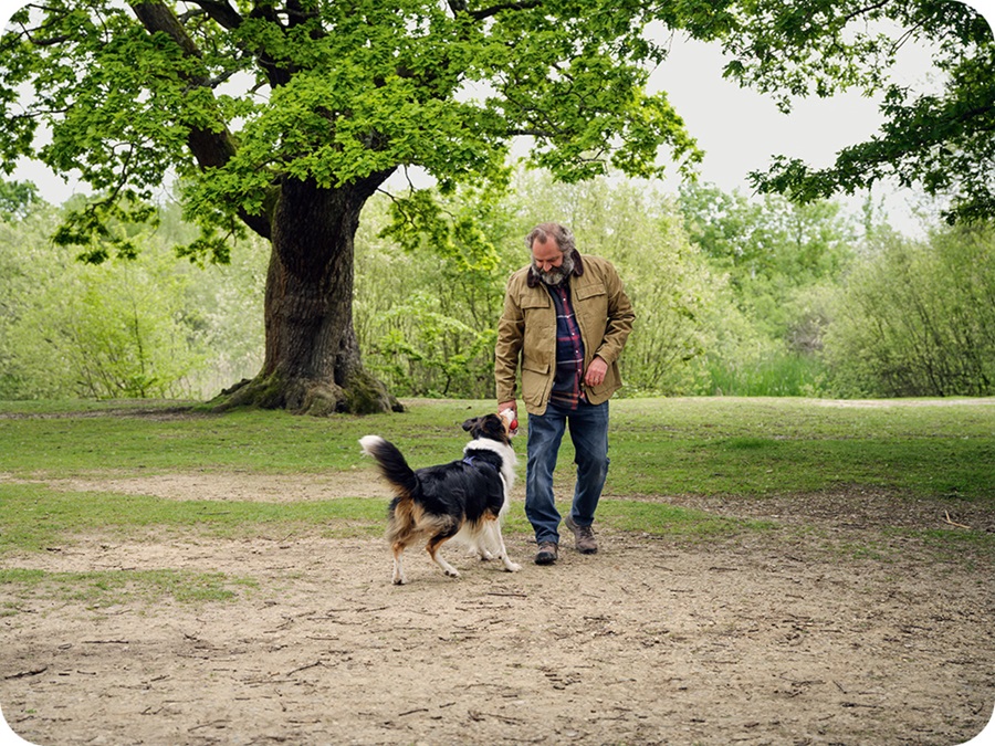 Hombre jugando con su perro en el parque.
