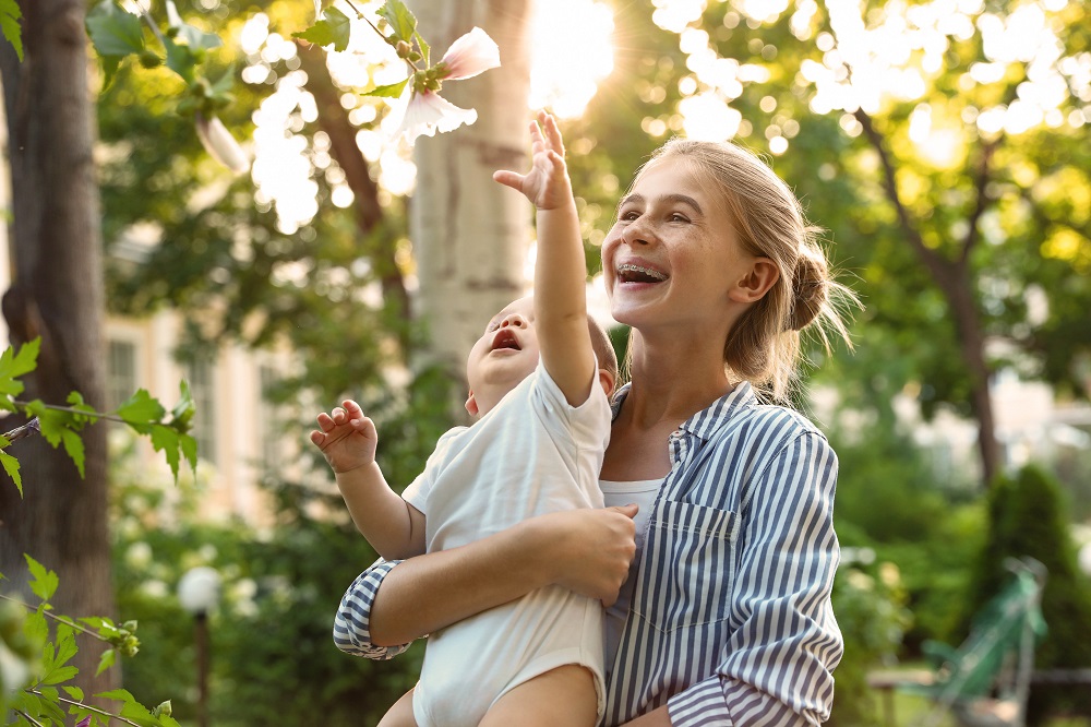 Meninigitis Meningocócica, adolescente con niño en brazos.