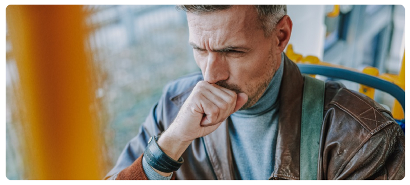 Hombre tosiendo se tapa la boca con la mano