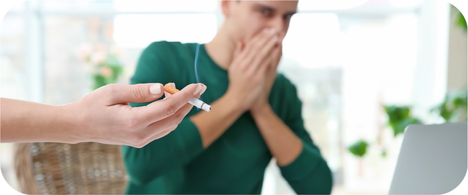 Hombre evitando respirar el humo ambiental del tabaco